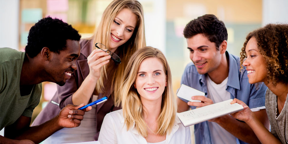 A smiling group of employees surrounds the boss, offering notebooks, pens, and glasses in an effort to please her. A smiling group of employees surrounds the boss, offering notebooks, pens, and glasses in an effort to please her.