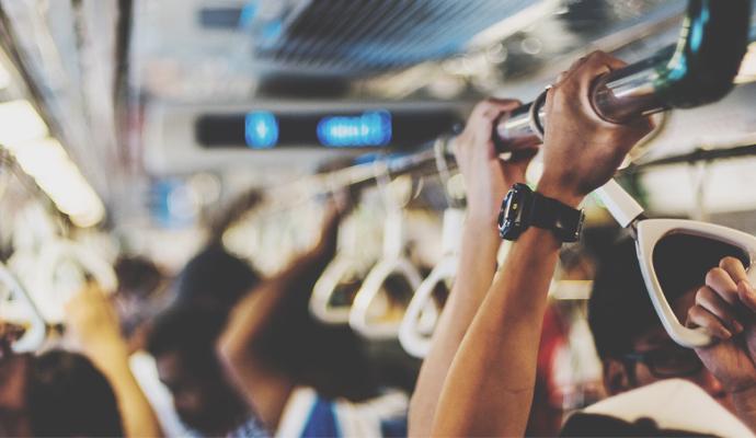A closeup image of a group of people holding onto straps on a mode of public transportation A closeup image of a group of people holding onto straps on a mode of public transportation
