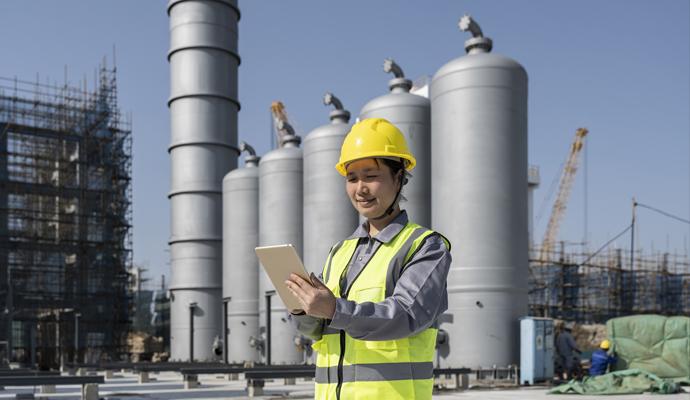 A female engineer works at the construction site of a chemical plant under construction A female engineer works at the construction site of a chemical plant under construction