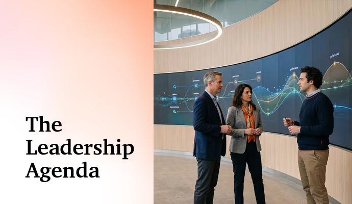 Three people meet in a modern building's lobby with a large digital display behind them. Three people meet in a modern building's lobby with a large digital display behind them.