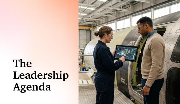 Two professionals stand beside industrial equipment and review information on a digital tablet. Two professionals stand beside industrial equipment and review information on a digital tablet.