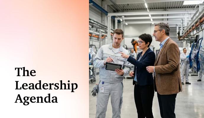Three professionals standing in a factory, reviewing information on a tablet. Three professionals standing in a factory, reviewing information on a tablet.
